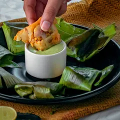 Experience a true coastal delicacy with our Pomfret steamed in banana leaves. The fish is marinated with subtle spices and lemon, then steamed to perfection, making it incredibly tender and aromatic.