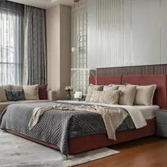 For this master bedroom, we focused on creating a layered and textured sanctuary. The custom bed with its deep red upholstery, the sleek bedside tables, and the coordinated loveseat were all crafted by us to work in harmony, resulting in a space that feels like a luxurious retreat.