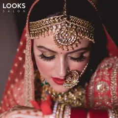 This is a beautiful example of a traditional North Indian bridal look. I used golden shimmer on the eyelids and a classic red lip to complement her stunning matha patti and nath. The HD makeup ensures she is picture perfect from every angle.