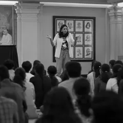 A black and white shot of me addressing a large group of college students. My goal in these workshops is to create a space where young adults can explore storytelling as a powerful tool for connection and self-expression.