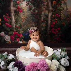 A sweet smile captured during the tub time photoshoot. The warm, milky water is comfortable for the baby, leading to relaxed and happy portraits.