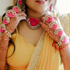 A close-up of a Haldi bride's details. The look features fresh, dewy skin and beautiful floral jewellery that is perfect for the occasion.