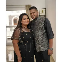 This client is wearing a custom black brocade Bundi jacket, designed to coordinate with his partner's black net gown for a wedding event.