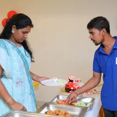 A staff member assists a guest at a birthday party buffet, showcasing our helpful service for smaller, intimate events.