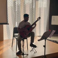 A student practices classical guitar for his ABRSM music exam at our school.