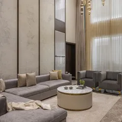 For this double-height living room, we crafted this large L-shaped sofa and armchairs to anchor the grand space. The clean lines and neutral grey upholstery provide a calm, sophisticated foundation, allowing the room's scale and light to take center stage.
