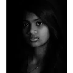 The same low-key portrait, presented in black and white. This conversion adds a timeless and classic quality to the image, emphasizing light and shadow.