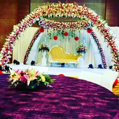 A closer view of a grand reception stage, highlighting the lush floral arch and elegant seating. The design ensures the couple is framed beautifully for photographs and ceremonies.
