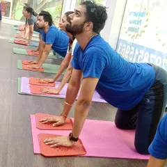 Students hold a cow pose on acupressure mats, combining a spinal stretch with the therapeutic benefits of acupressure.