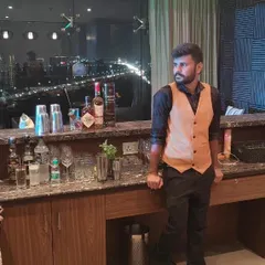 One of our lead bartenders posing at a fully stocked bar in a high-rise venue. This image showcases our ability to set up a professional bar service in any location, complete with premium spirits and equipment.