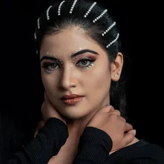 A powerful portrait from our creative shoot. The sharp, defined eye makeup and strategically placed face gems create a look that is both edgy and beautiful.