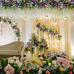 For a soft and romantic reception, I designed this stage with lush pastel florals, elegant chandeliers, and warm lighting. The hanging wisteria and dense flower arrangements create a dreamy, luxurious feel.