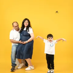A fun and playful family maternity session. The bright yellow background adds a cheerful energy as this family of three gets ready to become a family of four.