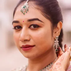 A close-up of the soft glam makeup. You can see the neat eyeliner, subtle eyeshadow, and a berry-toned lip color that perfectly matches the client's traditional South Indian jewelry and attire.