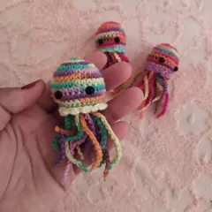 Another look at the tiny rainbow jellyfish charm held in my hand. The mix of colors makes each one a unique piece of art.