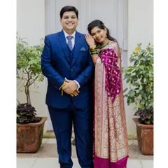 A full-length portrait of Alok and Shilpa. The bride's rich magenta Paithani saree and the groom's classic blue suit make a beautiful combination.
