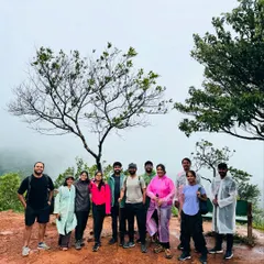 Posing by a distinctive tree on the Tadiandamol trail, with the misty hills of Coorg in the background.