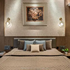 A close-up of a master bedroom where warm wood paneling creates a cozy backdrop. The space is personalized with elegant wall sconces and a meaningful piece of art, making it a true sanctuary.