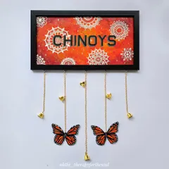 For this custom nameplate, I combined a fiery orange mandala background with bold lettering. The hanging monarch butterflies and bells make it a truly unique and personal entrance piece for the 'Chinoys' home.