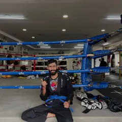 Taking a moment to rest on the edge of the ring after a BJJ session. The ground game requires a different kind of endurance and intelligence.