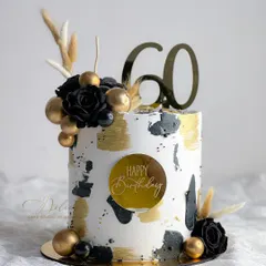 A special cake for a 60th birthday. This design features a modern black, white, and gold abstract pattern, decorated with dried pampas grass for a contemporary look.