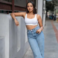A relaxed, full-body portrait against a clean, architectural wall. This type of shot is perfect for showcasing an entire outfit in a natural urban environment, focusing on style and pose.
