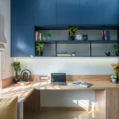 This contemporary study space blends functionality with elegance. The design features a deep blue and wood aesthetic, an L-shaped desk for ample workspace, and smart overhead storage to keep the area clutter-free.
