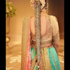 A focus on the details. This look features a stunning traditional braid accessory, known as a jada, complementing a multi-colored lehenga by Anuradha Vakil.