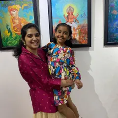 An artist with a young family member enjoying the exhibition, highlighting the community atmosphere.