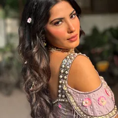 A beautiful over-the-shoulder shot of this Mehendi look. You can see the details of the romantic waves, tiny braids, and delicate floral hairpins.