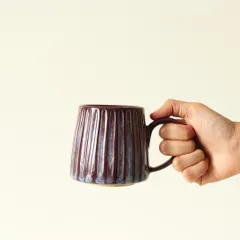 There's nothing like a favorite mug for your morning coffee. This 'Aubergine Drip' mug, with its deep, iridescent glaze and hand-scooped texture, is designed to fit perfectly in your hands and brighten your day.