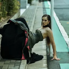 An unconventional pose on a Tokyo sidewalk. This is about finding interesting shapes and lines in an urban environment and using them to create a unique, high-fashion image.