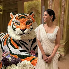 A closer look at my "Indian chic" outfit for the Ambani wedding, posing next to a magnificent floral tiger. The all-white ruffled saree felt elegant and perfect for the grand occasion.
