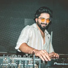 It's about authenticity, not perfection. A shot of me smiling at the deck, enjoying the process of mixing and creating a vibe for the dance floor.