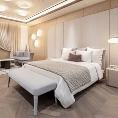 A minimalist bedroom in a Gurgaon apartment, designed for simplicity and flow. The space features a custom bed with a light wood frame and a matching bench, set against a paneled wall. The design creates a soft, serene atmosphere that feels both elevated and deeply restful.
