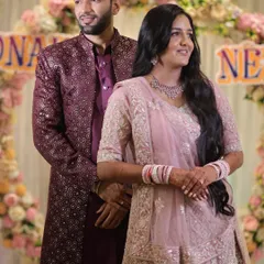 A lovely portrait of a couple at their engagement ceremony. The bride's makeup is soft and minimal, with a pink toned palette to match her pastel pink lehenga and diamond jewelry.