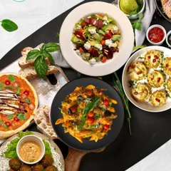 Experience a taste of Italy with our gourmet vegetarian catering. This spread showcases some of our Italian favorites, including artisanal pizza, fresh pasta, flavorful falafel, and a vibrant salad, perfect for a sophisticated dinner party or a casual get-together.