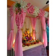 For a soft and elegant look, I designed this pink-themed Ganpati mandap. The setup includes a canopy of pink and white cherry blossoms, flowing pink drapes, and hanging jasmine garlands.