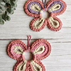 These macrame butterflies were customized for a newborn baby girl's room. The soft pink and purple colors are perfect for a nursery, and they add a touch of handmade sweetness.