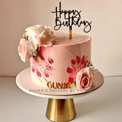 A surprise birthday cake for a wife, this design features soft pastel pink frosting, delicate palette knife flowers, and hand-placed golden sprinkles for a touch of sparkle.