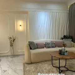 I believe in creating living rooms that are both serene and stylish. This space uses a soft, neutral palette, a plush curved sofa, and elegant 3D wall paneling to create a minimalist yet luxurious feel. The design focuses on texture and light to make the room feel warm and inviting.