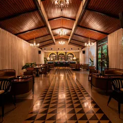 A long shot down the main hall of Vamos Experience at night. This photograph captures the moody, sophisticated atmosphere created by the chandeliers and accent lighting, showcasing the venue's transformation from day to night.