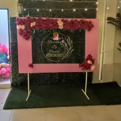 A custom photo booth frame is a great addition to any birthday party. This standalone pink frame, decorated with beautiful artificial roses, provides a dedicated spot for guests to take memorable pictures.