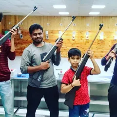 A family poses with their air rifles after a fun session at our range. Our guest shooting is open to ages 11 and up, making it a safe and exciting activity for the whole family.
