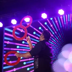 A stunning shot of our juggler in action, skillfully manipulating rings under vibrant stage lights. This act adds a touch of elegance and mesmerizing skill to any performance.