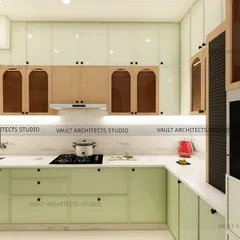 A closer look at the details of this sage green modular kitchen. The design features handleless drawers, upper cabinets with glass inserts, and a built-in oven unit, all planned for ergonomic use and a sleek appearance.