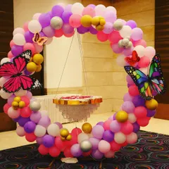 A brightly lit version of our butterfly theme decor. The colorful balloon ring with butterfly accents and the unique hanging cake stand create a magical and memorable setup for a birthday party.