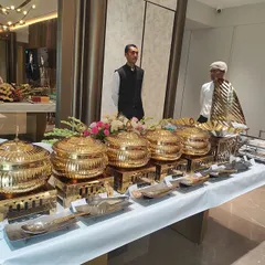 Our full-service catering is designed so you don't have to lift a finger. We provide an elegant and professional buffet setup, complete with these beautiful gold-finish chafing dishes to keep food warm, all the necessary crockery, and our trained, uniformed staff to manage the service.