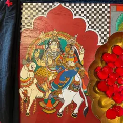 A close-up of the central panel depicting Shiva and Parvati, hand-painted in the Kalamkari style. The rich red background and intricate details showcase the fusion of devotional art with furniture restoration.