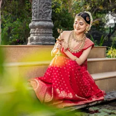 This image, with the lamp, evokes a feeling of tradition and divinity. The jewellery set includes a matha patti and layered necklaces, perfect for a classic bridal shoot.